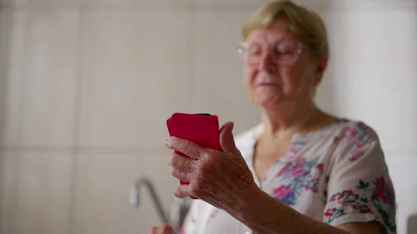 精通技术的老年妇女使用电话 持有手机装置的80多岁女性 — 图库照片