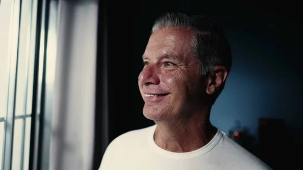 Szczęśliwy Starszy Mężczyzna Średnim Wieku Uśmiecha Się Patrząc Przez Okno — Zdjęcie stockowe