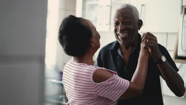 快乐的巴西黑人夫妇在家庭厨房里愉快地跳舞 与老年男女的真正浪漫时刻 — 图库视频影像