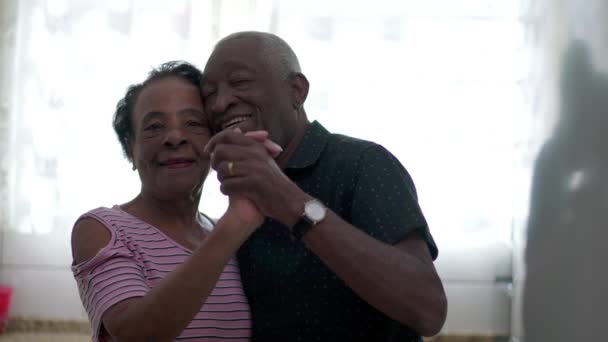 一对快乐的巴西黑人夫妇在家里的厨房里跳舞 非裔美国老年男子和妇女面面相觑 — 图库视频影像