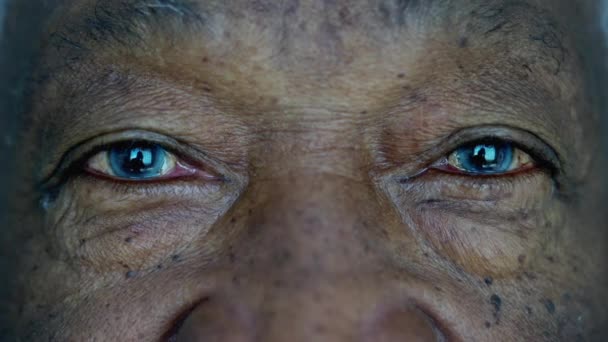 シニアアフリカ系アメリカ人マクロクローズアップ目と顔カメラを見て 青い目を持つ高齢者の黒人 — ストック動画