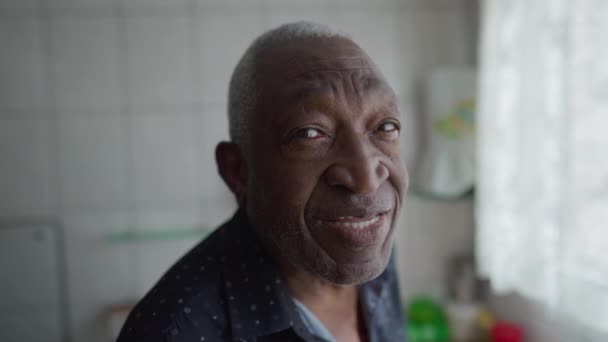 一位巴西黑人老年男子站在厨房窗边 面对镜头笑着 非裔美国人老年人 — 图库视频影像