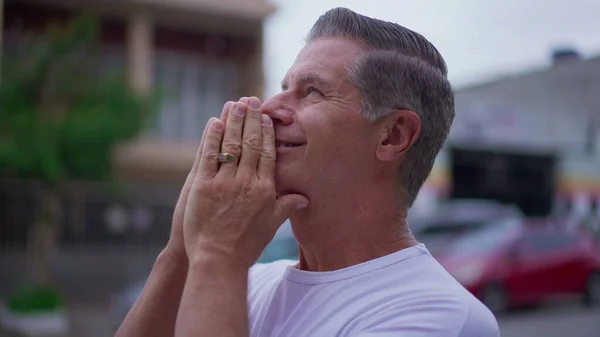 stock image Religious Senior man standing on street in Prayer. Devoted middle-age male caucasian person Praying to God looking at sky smiling exuding HOPE and FAITH