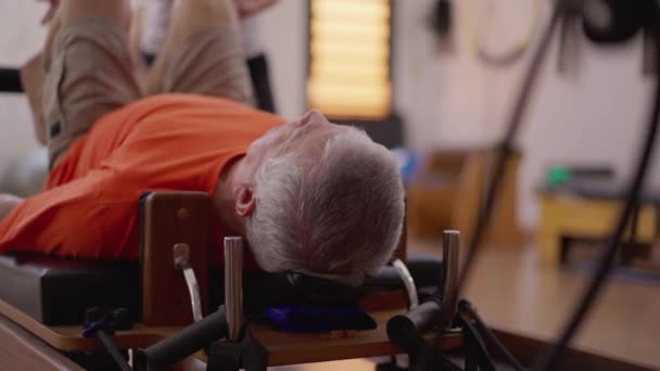 Uomo Anziano Che Esercita Pilates Macchina Guidata Una Femmina Pilates — Video Stock