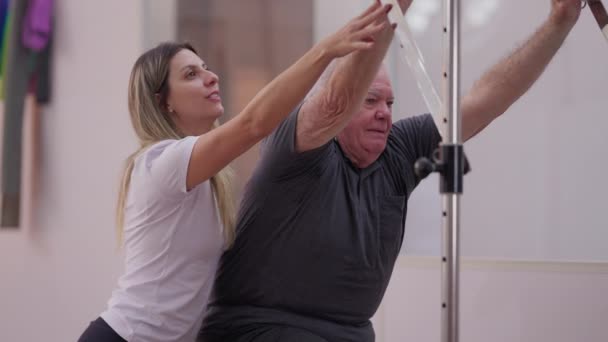 Trener Pilates Pomaga Starszemu Mężczyźnie Obsłudze Maszyny Starszy Mężczyzna Starszy — Wideo stockowe