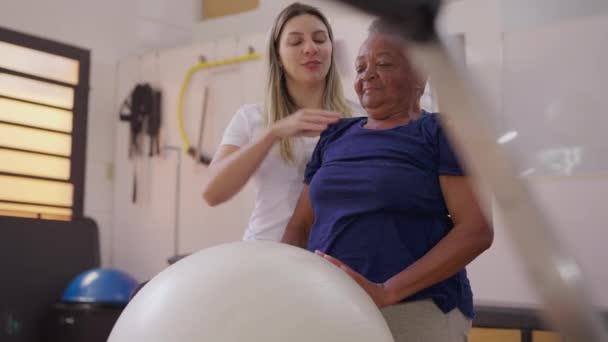 Pilates Trenér Asistence Starší Brazilské Ženy Ball Cvičení Fyzioterapii Studio — Stock video