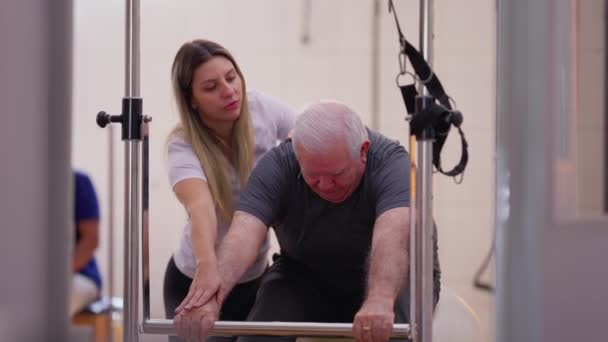 Kadın Fizyoterapist Koç Son Sınıf Öğrencisine Pilates Makinesi Ile Egzersiz — Stok video