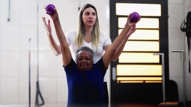 Kadın Pilates Eğitmeni Siyah Yaşlı Bir Kadına Ağırlık Çalışması Için — Stok video