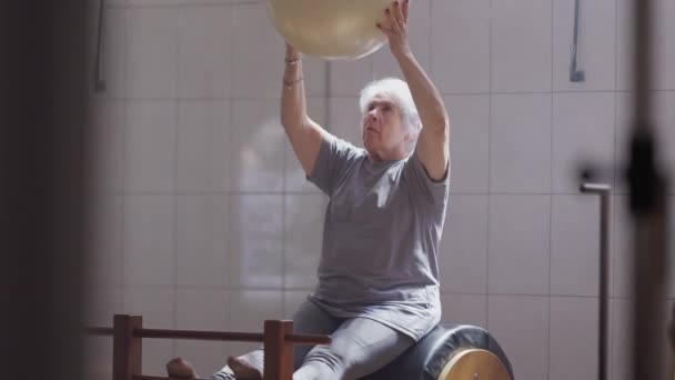 在普拉多演播室用球做运动的老年犬女 老年人的日常锻炼 老太太的肌肉和柔韧性增强了 — 图库视频影像