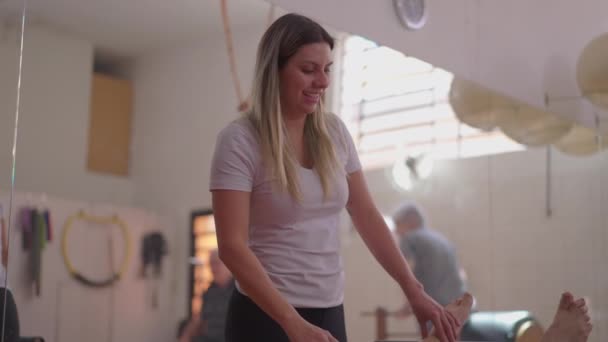 Γυναίκα Pilates Δάσκαλος Βοηθώντας Ηλικιωμένος Άνθρωπος Μηχανή Στη Φροντίδα Του — Αρχείο Βίντεο