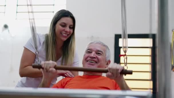 필라테스 코치의 도움을 운동하는 남자는 행복하다 노인들은 정기적으로 건강을 노력한다 — 비디오