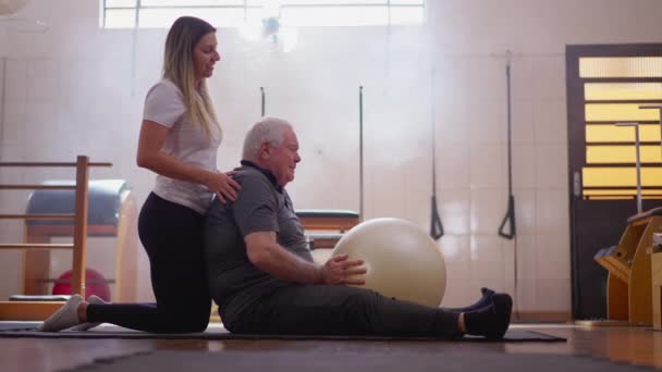 Pilates Koçu Yaşlı Insana Egzersiz Sırasında Egzersiz Yapmasını Söylüyor Fizyoterapi — Stok video
