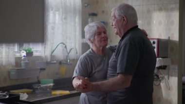 Yaşlı çift mutfakta romantik bir dansın tadını çıkarırken, koca dans ederken, gizli aşk ve samimiyet gösterisi yapıyor.
