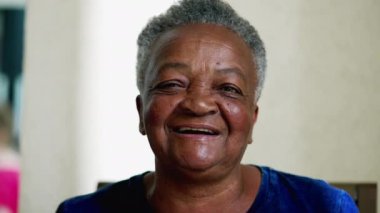 Gülümseyen ve gülen mutlu siyah, son sınıf öğrencisi bir kadın. Neşeli dost canlısı yaşlı Afrikalı Amerikalı