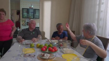 Farklı kıdemli arkadaşlardan oluşan gizli bir grup otantik yerli günlük sahne ile oturma odasındaki masada konuşuyor. Brezilyalı yaşlılar hafta sonu yemeğinde birlikte takılıyor.
