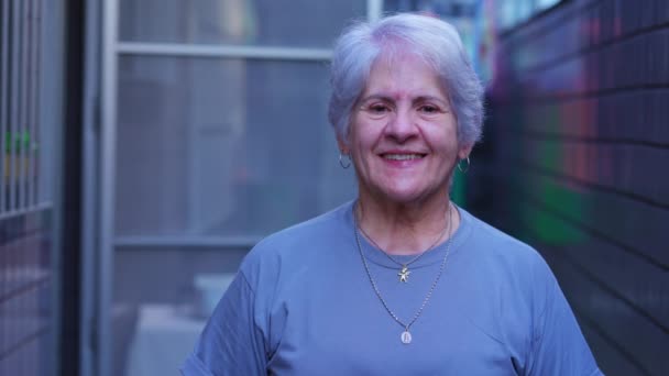 Μια Χαρούμενη Ηλικιωμένη Γυναίκα Χαμογελάει Στην Κάμερα Έξω Από Σπίτι — Αρχείο Βίντεο