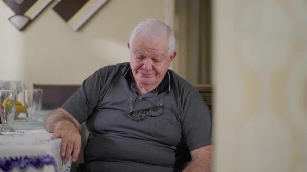 Σκεπτικός Ηλικιωμένος Που Κάθεται Μόνος Του Στο Σπίτι Κοιτώντας Κάτω — Αρχείο Βίντεο