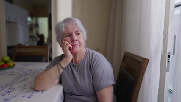 Mujer Anciana Contemplativa Sentada Junto Ventana Casa Mirando Hacia Fuera — Vídeos de Stock