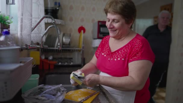 一位快乐的老妇人正在厨房洗碗 一位快乐的资深高加索人在镜头前微笑 — 图库视频影像