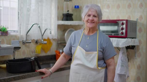 Una Mujer Mayor Usando Delantal Pie Junto Fregadero Cocina Sonriendo — Vídeos de Stock