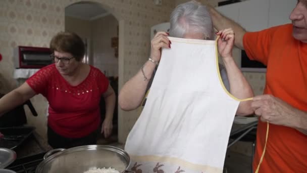 年配の女性がエプロンをして昼食を作る準備をしている 白髪の老婦人が料理のルーチンを準備しています — ストック動画