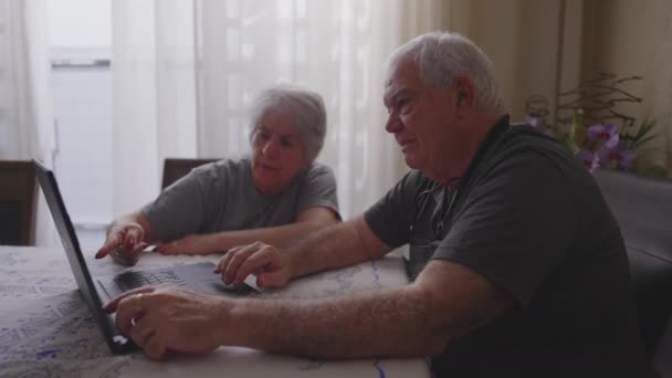Older Couple Home Navigating Internet Laptop Elderly Husband Showing Content — Stock Video