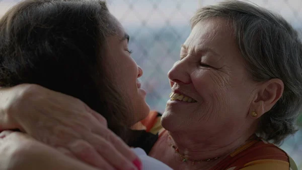 stock image Joyful grandmother embracing and kissing family member. Senior woman hugging grandchild, authentic reunion