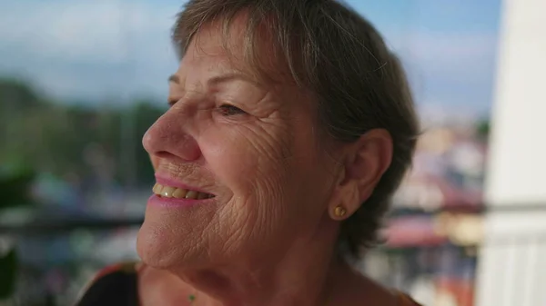 从公寓阳台上看城市景色时 快乐的老年女性形象面带微笑 快乐的老太太 — 图库照片