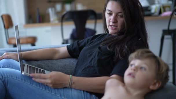 Мать Многозадачна Малышом Дома Используя Ноутбук Откровенная Подлинная Реальная Жизнь — стоковое видео