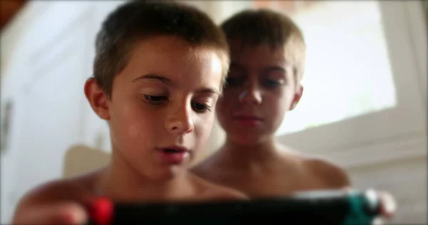两个兄弟在家里玩电子游戏 拿着科技装置玩游戏的孩子 — 图库照片