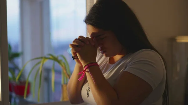 20代の宗教的な大人の女の子神への祈り 家で日没の間に手を握りしめ — ストック写真