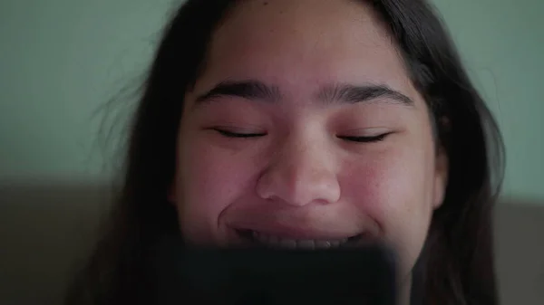 快乐的巴西少女拿着手机对网上的内容反应积极 特写一个快乐多样的亚洲女人笑着看信息的照片 — 图库照片