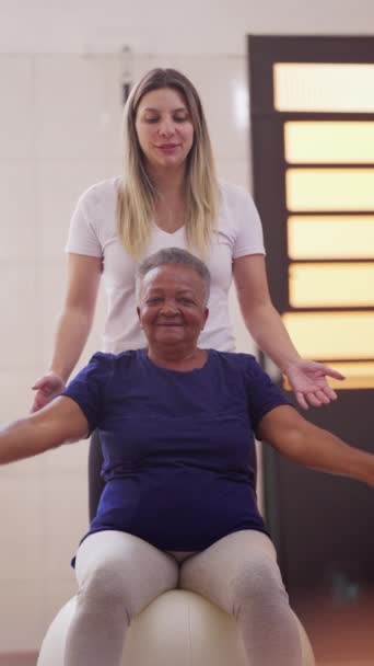 Fitness Coach Assisting Senior Black Woman Pilates Träna Med Bollar — Stockvideo