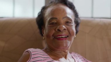 Gülümseyen mutlu siyah yaşlı bir kadın. Kameraya bakan Afrikalı Amerikalı yaşlı bir kadının yakın plan yüz resmi.