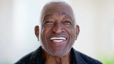 Mutlu, arkadaş canlısı, son sınıf siyahi bir adam yakından gülüyor ve gülümsüyor. 70 'lerde Afro-Amerikalı neşeli bir erkeğin portresi.