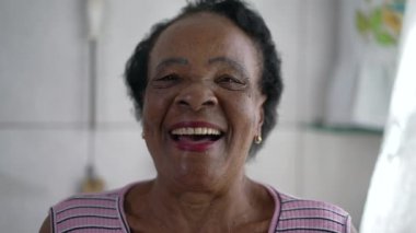 Gülen ve gülümseyen mutlu siyah bir son sınıf kadını. Afro-Amerikalı yaşlı birinin neşeli yakın plan yüzü otantik gerçek hayat gülüşü ve gülümsemesi, dost canlısı karizmatik ifade