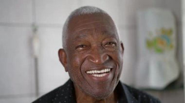 Kameraya gülümseyen ve gülen yaşlı siyah Brezilyalı bir adamın yakın plan yüzü. 70 'li yaşlarda, otantik bir gülümsemesi olan Afrikalı bir Amerikalının portresi.