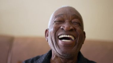 Siyah Brezilyalı neşeli bir adam kameraya gülümsüyor ve gülüyor. Arkadaş canlısı karizmatik Afrikalı Amerikalı yaşlı kişi