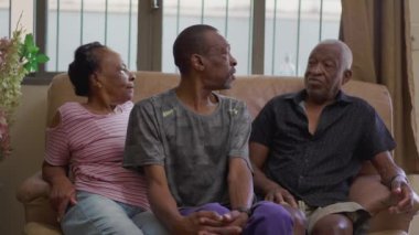 Evde aile sohbeti, kanepe etkileşimi. 50 'li yaşlarda yetişkin bir çocukla yaşlı yaşlılar arasında samimi ve otantik bir ilişki.