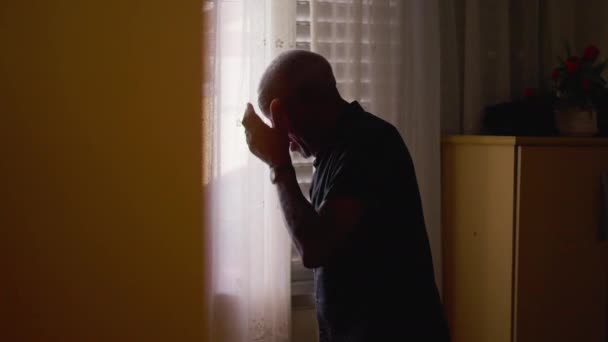 一个绝望的黑人老人在家里的窗边遗憾地捂着手 与精神疾病作斗争的人 — 图库视频影像