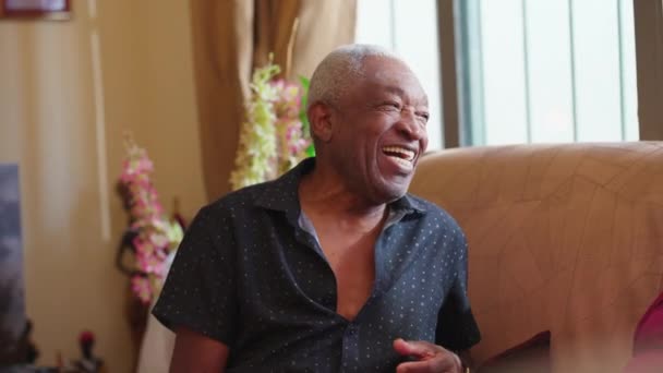 坐在沙发上快乐的非洲裔美国老人 的真正快乐的笑声 真实而快乐的巴西老年人 — 图库视频影像