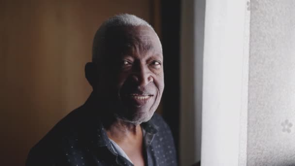 一个黑人老人站在窗边 对着摄像机笑的画像 一个巴西老年人 — 图库视频影像