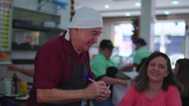 Χαρούμενος Ανώτερος Σερβιτόρος Λαμβάνοντας Παραγγελίες Τροφίμων Ένα Χαμόγελο Που Ασχολούνται — Αρχείο Βίντεο