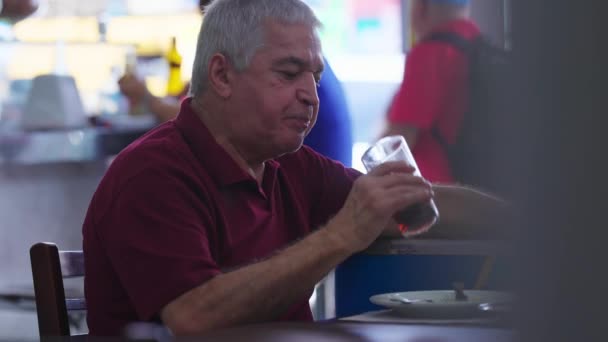 レストランで高齢者の飲料ソーダを候補 昼食の時間帯には カジュアルな年上の男性の原因アジア人が砂糖を飲みながら飲みます 食の休憩 — ストック動画