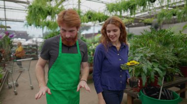 Önlük Giyen Erkek Çiçekçi Dükkandaki Çiçek Seçen Müşteriye Yardım Ediyor