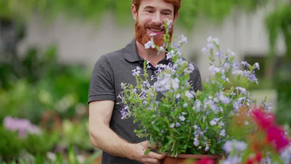 園芸小売店舗の男_棚から花を選ぶ 幸せな白人男性 植物のためのショッピング — ストック写真