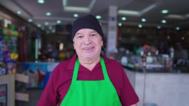 Kafeteryanın kendinden emin kıdemli çalışanı restoranın önünde duruyor, yerel iş yemekleri servisi yaşlı beyaz personel