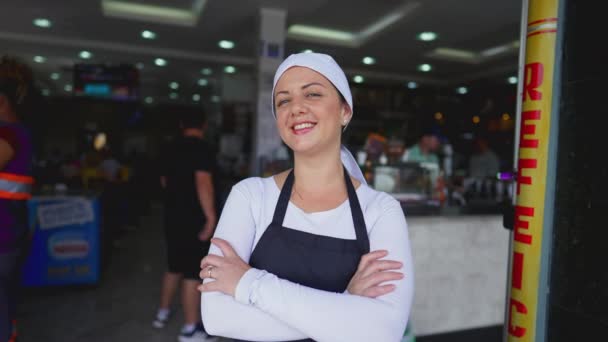 餐饮业前Apron Stands自信的女服务员 双手叉腰对着相机微笑 — 图库视频影像