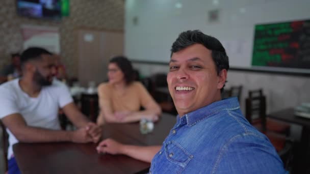 Hombre Brasileño Feliz Sentado Restaurante Con Amigos Gira Cabeza Hacia — Vídeos de Stock