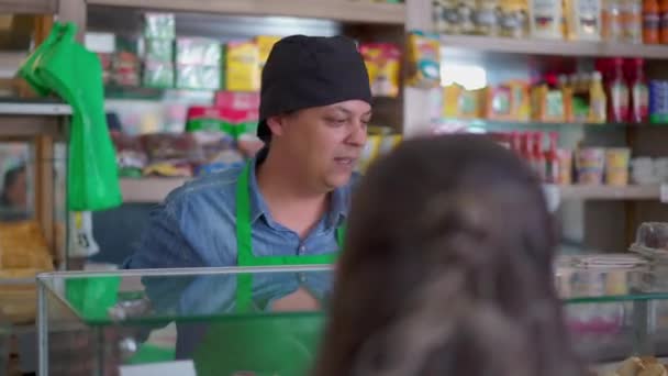 顧客との対話の背後にあるデリの従業員 人と話すカフェテリアの男性スタッフ 食品の買い物 — ストック動画